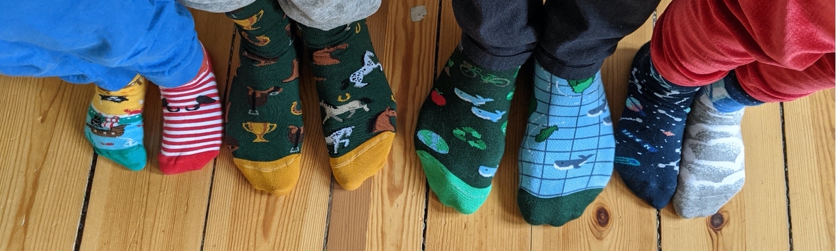 Four pairs of colorful socks on a wooden floor