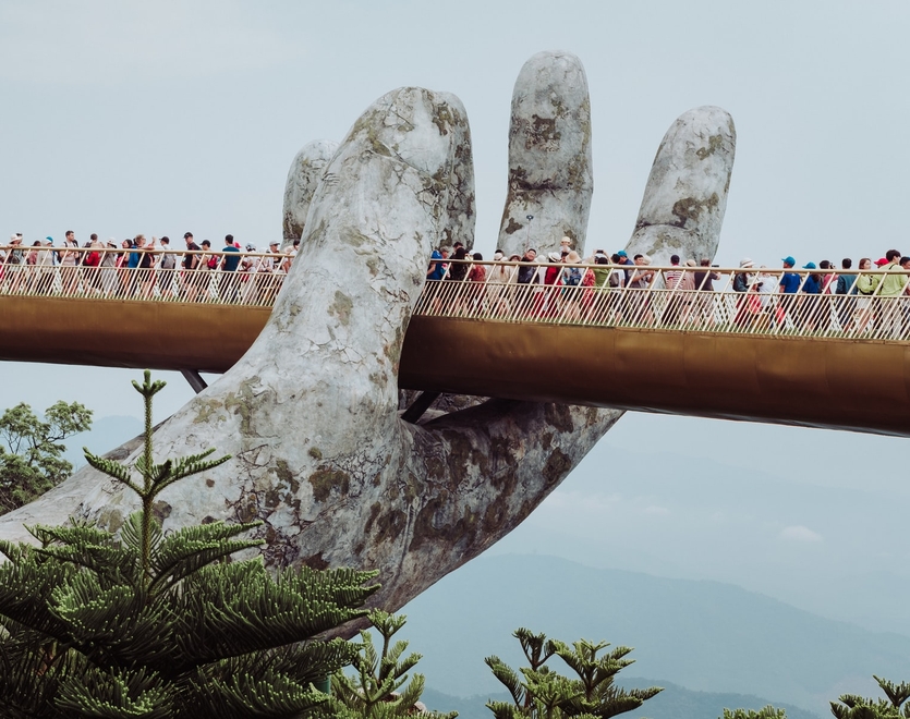 Golden Bridge on Ba Na Hills, Vietnam, Da Nang. A crowded bridge embedded in a large sculpture.